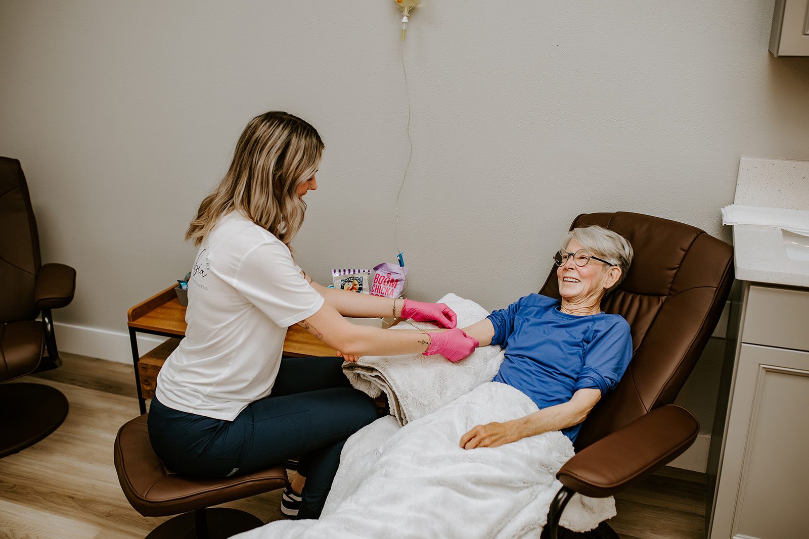 A Silique IV Hydration nurse starting an IV drip for a client resting in a treatment chair in Lake City, FL